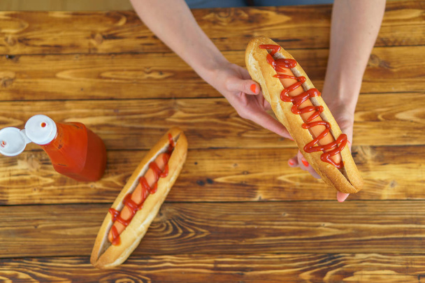 Womans ręce jest gospodarstwa hot dog, wideo widok z góry - Zdjęcie, obraz