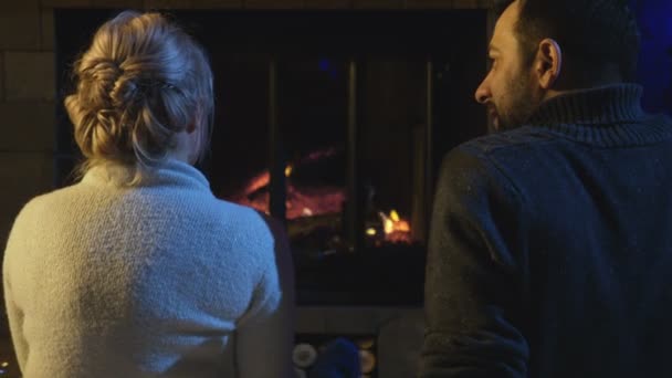 Házaspár egy égő tűz előtt ülve - Felvétel, videó