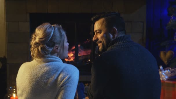 Házaspár egy égő tűz előtt ülve - Felvétel, videó