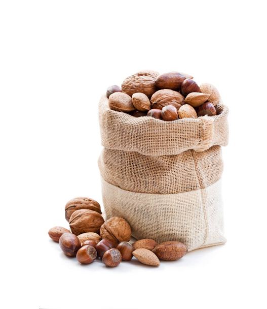 Various  nuts in sackcloth bag isolated on white  - Fotografie, Obrázek