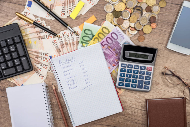 text rozpočet na Poznámkový blok, euro bankovky a mince, kalkulačka, brýle, telefon - Fotografie, Obrázek