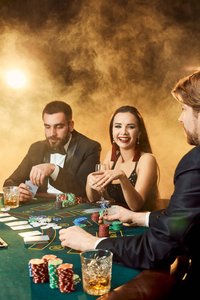Ομάδα νέων πλούσιων ανθρώπων παίζει πόκερ στο καζίνο - Φωτογραφία, εικόνα
