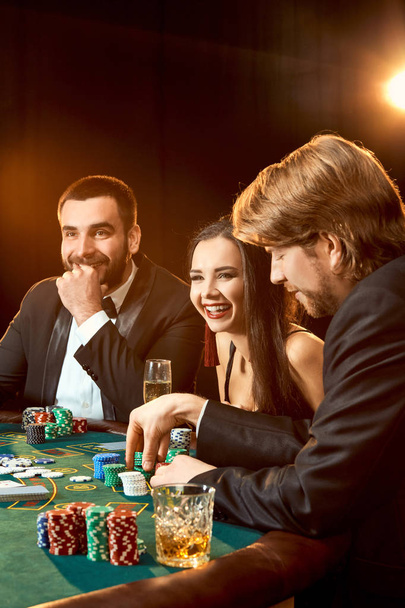 Grupa młodych bogatych ludzi gra w pokera w kasynie - Zdjęcie, obraz