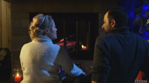 Παντρεμένο ζευγάρι κάθεται μπροστά από μια φωτιά που καίει - Πλάνα, βίντεο