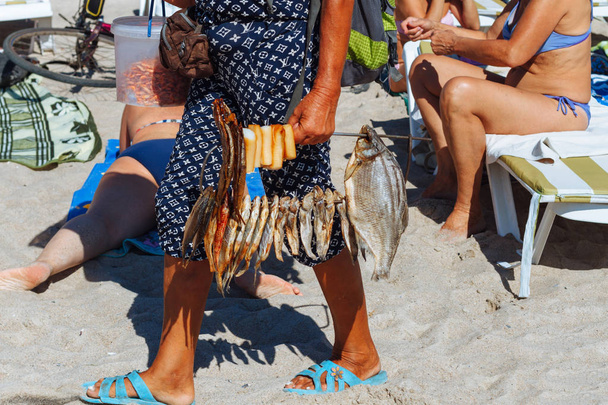 A woman sells dried fish at the beach. - Photo, Image