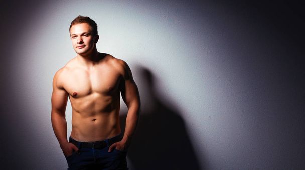 Healthy muscular young man. Isolated on black background - Foto, Bild