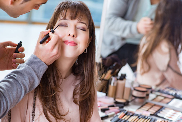 Mann macht Make-up für süße Frau im Schönheitssalon - Foto, Bild