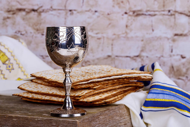 Fiestas judías Pesaj matzá Pascua y una copa de plata llena de vino con una bendición tradicional
 - Foto, imagen
