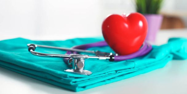Un estetoscopio dando forma a un corazón y un portapapeles en un uniforme médico, primer plano
 - Foto, imagen