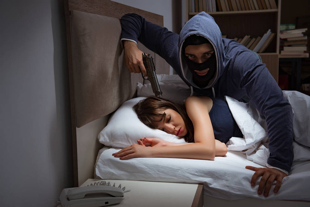 Murtovaras murtautuu taloon yöllä makuuhuoneeseen nukkumalla wo - Valokuva, kuva