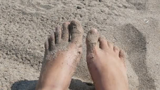 Erkek tabaklanmış bacaklarını ve sahilde kum arka planı parmakları hareket - Video, Çekim