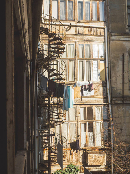 トビリシ, ジョージア, 2018年 1 月。さびた螺旋階段、晴れた日に外で乾燥の服が付いている古いトビリシ ヤード - 写真・画像