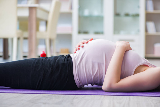 Pregnant woman exercising in anticipation of child birth - Photo, Image