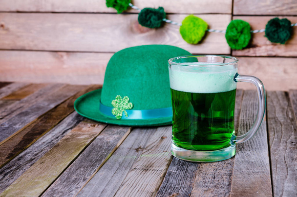 Кружка зеленого пива в ирландской праздничной шляпе
 - Фото, изображение