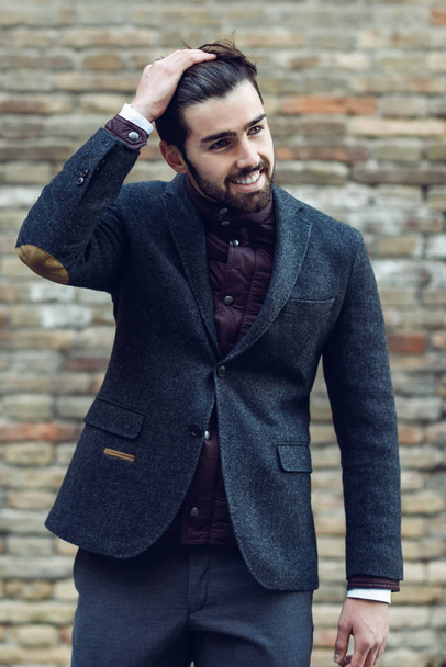 Giovane uomo barbuto sorridente in sfondo urbano indossando britannico el
 - Foto, immagini