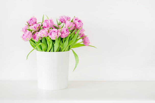 Fresh bright bouquet of pink tulip in white bucket. Beautiful greeting card. Spring holidas concept. Copyspace. Place for your text - Photo, Image