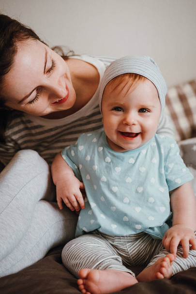 Söpö pieni hymyilevä vauva tyttö nauraa äidin kanssa hänen huoneessaan
 - Valokuva, kuva