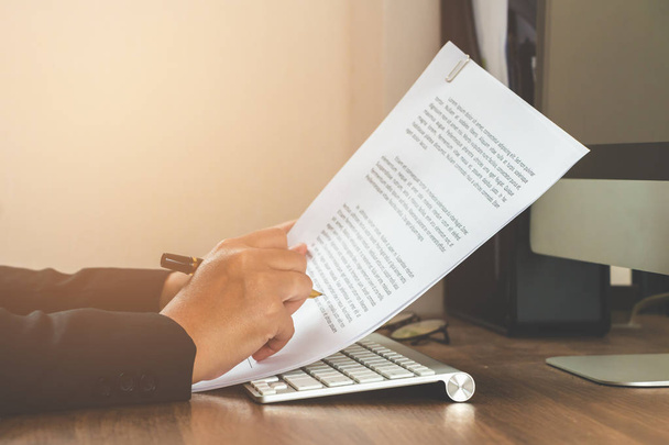Femme d'affaires lecture document papier sur table de travail
  - Photo, image