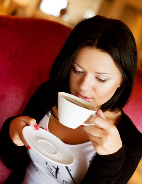 young woman sitting in a cafe drinking coffee - Фото, зображення