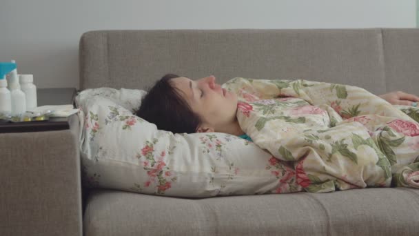 Jonge vrouw liggend op het bed met een hoest - Video