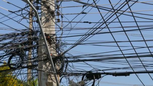 Manojos enredados de cables aéreos. Sistema eléctrico en las calles de Pattaya, Tailandia. Angulo de alambres en poste sobrecargado de los servicios públicos en la bandeja del nivel del alambre de Tailandia
 - Imágenes, Vídeo