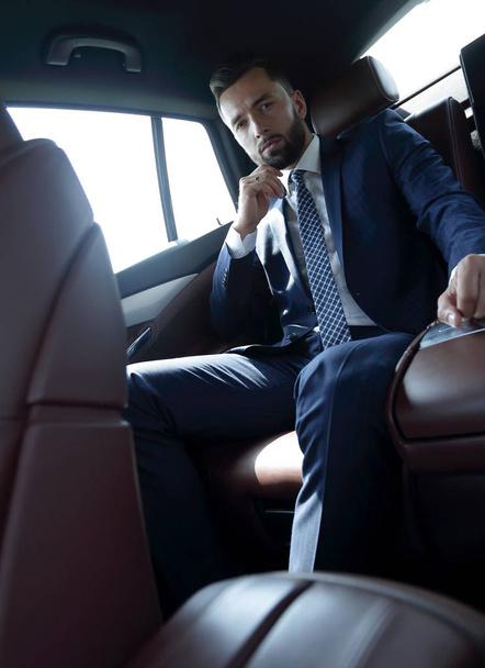 Successful businessman sitting in the back seat of a car - Foto, afbeelding