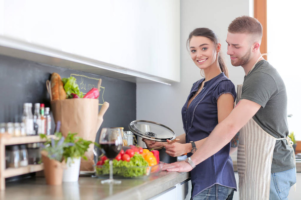 Couple cooking together in their kitchen at home - Foto, imagen