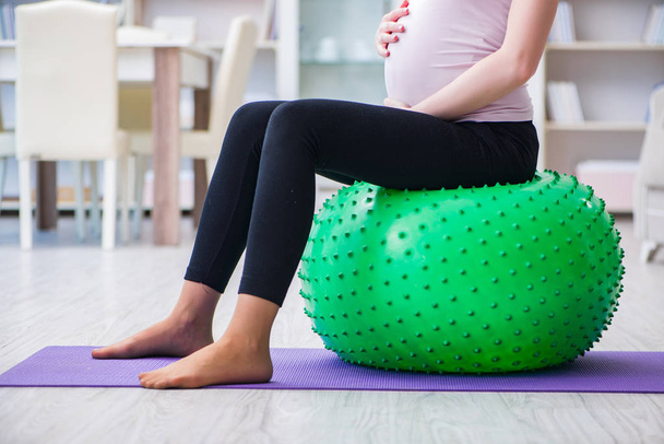 Mujer embarazada que hace ejercicio en previsión del parto - Foto, imagen