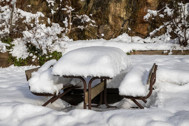 Stół i ławki, pokryte śniegiem w ogrodzie zimowym - Zdjęcie, obraz