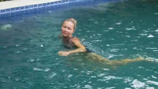 Happy young woman relaxing by the luxury swimming pool - Metraje, vídeo