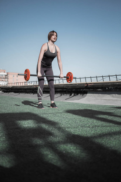Young woman doing inclines with barbell. - Photo, Image