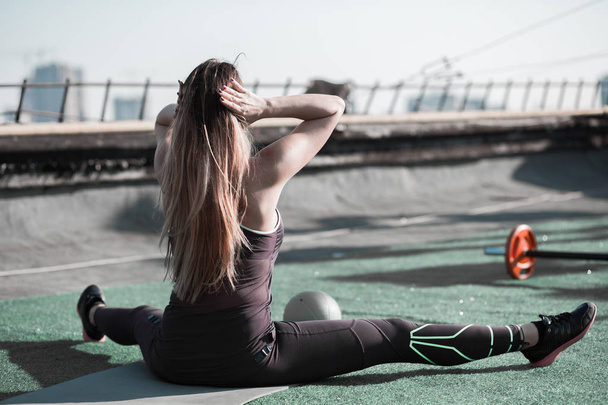 Sport on the roof, long haired woman working out. - Photo, Image