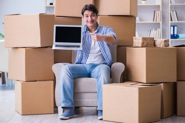 Молодой человек переезжает в новый дом с коробками - Фото, изображение