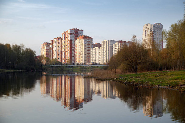 The view from city Park on a pedestrian bridge and a new neighborhood on the banks of the Pekhorka river. Balashikha, Moscow region, Russia. - Zdjęcie, obraz