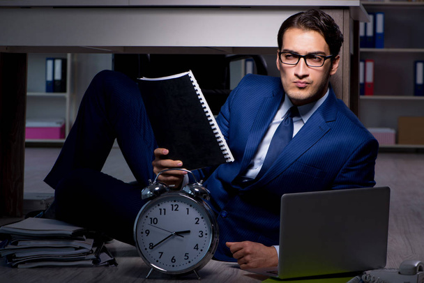 Zakenman die overuren maakt, lange werktijden te laat op kantoor - Foto, afbeelding