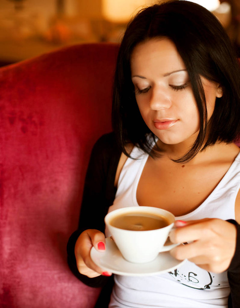 young woman sitting in a cafe drinking coffee - Fotoğraf, Görsel