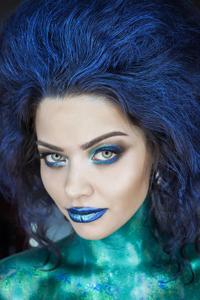 Retrato de una hermosa sirena. Piel húmeda, cabello mojado, brillo y escamas en la cara. Ojos azules. La imagen en Halloween. Espacio publicitario
 - Foto, Imagen