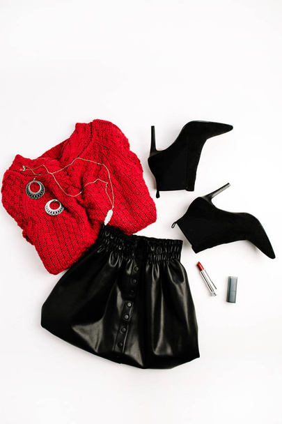 Des vêtements féminins. Pull rouge, jupe noire, chaussures et rouge à lèvres. Couché plat, vue de dessus look femme
. - Photo, image