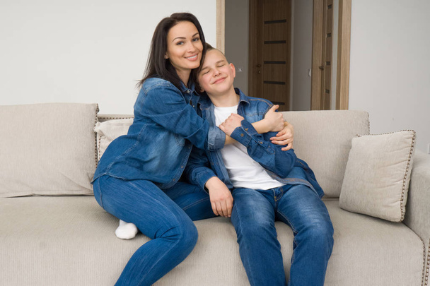 Portrait of mother and her son on sofa at home - Valokuva, kuva