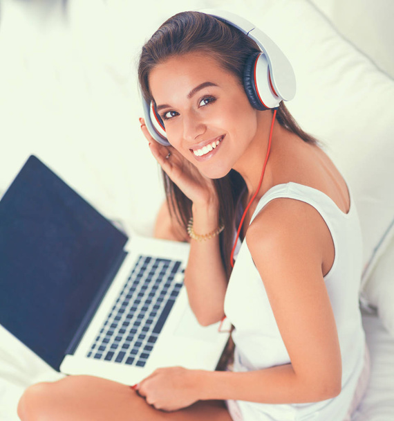 Young beautiful woman in bed listening to music - Photo, Image