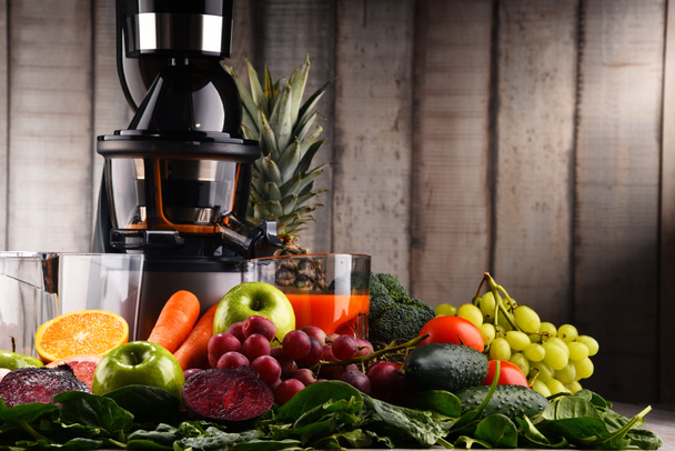 Медленная соковыжималка с органическими фруктами и овощами
. - Фото, изображение