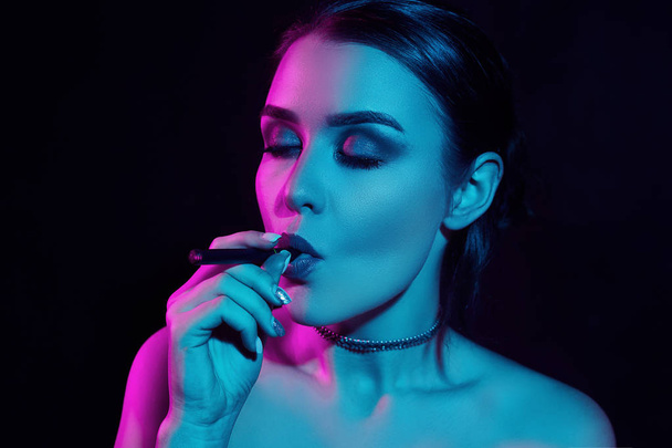 Glamour seductive gorgeous brunette woman smoking electronic cigarette - Photo, image