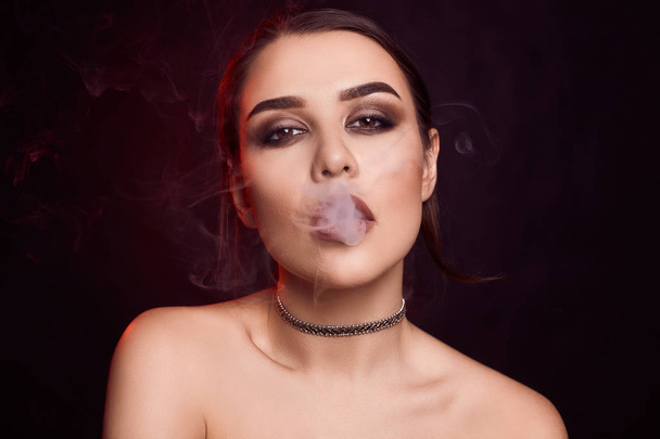 Glamour csábító gyönyörű barna nő elektronikus cigaretta a dohányzás - Fotó, kép