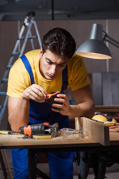 Worker working in repair workshop in woodworking concept - Photo, Image
