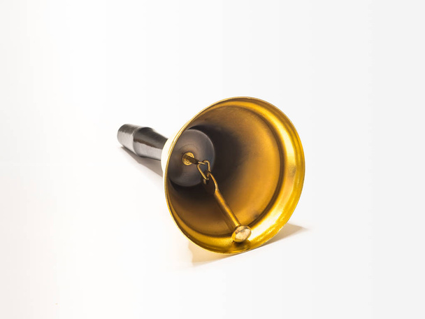 Pozlacené zvon s rukojetí vyrobený z černého plastu, izolované na bílém pozadí - Fotografie, Obrázek