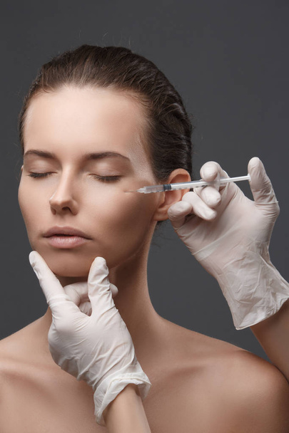 Portrait of young Caucasian woman getting cosmetic injection - Foto, Imagem