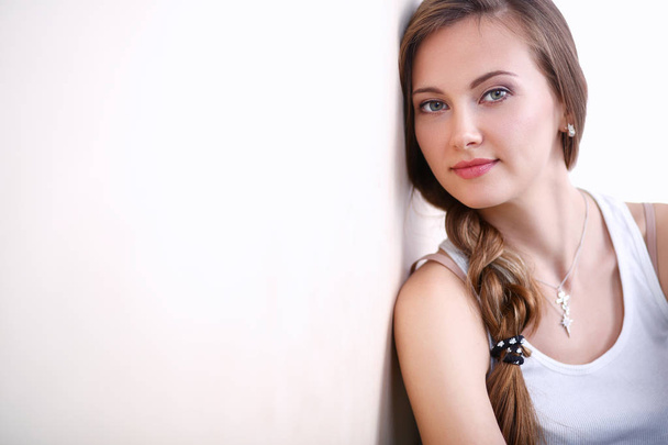 Young woman sitting on the floor near wall . Young woman - Foto, Bild