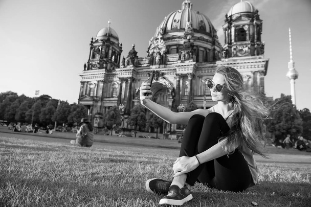 Pretty gil sitting in front of Berlin Cathedral doing selfie - Fotografie, Obrázek
