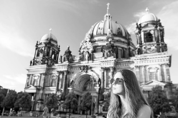 Pretty gil sitting in front of Berlin Cathedral wearing sungluss - Foto, Bild