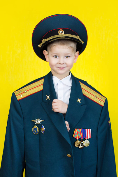 A little boy in the military uniform of his father. - Foto, imagen